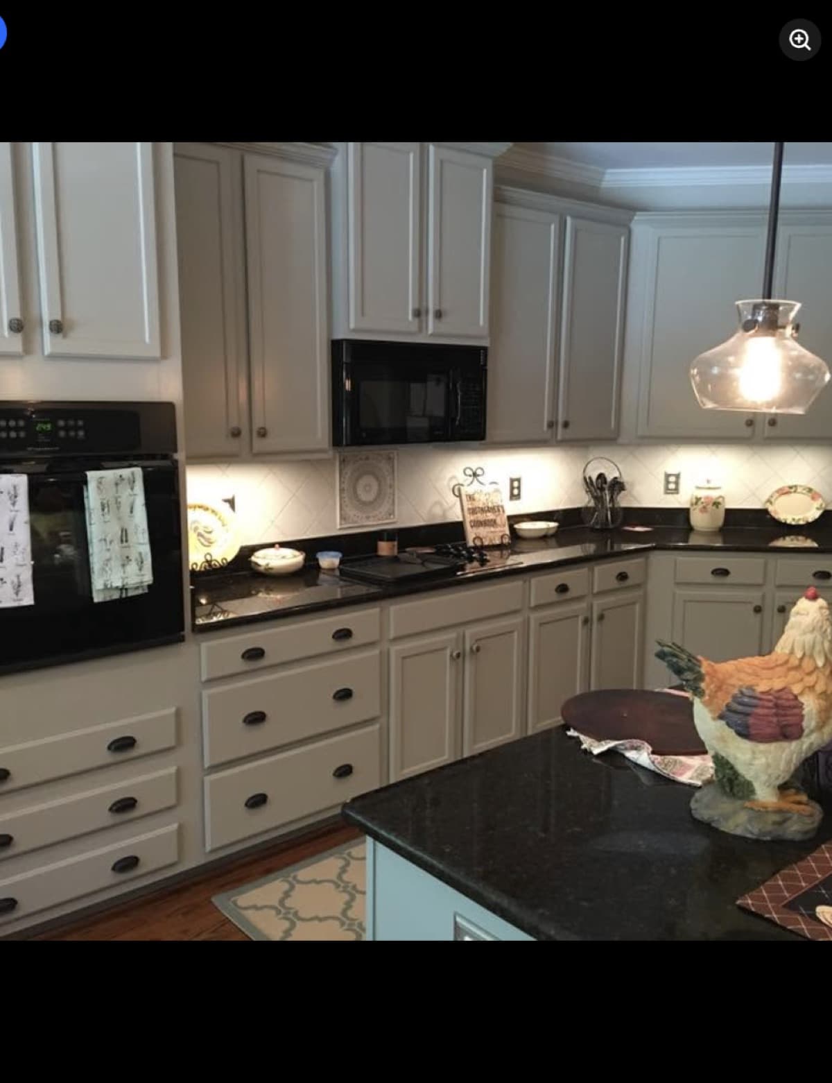 Kitchen remodel with black countertops and cream cabinetry